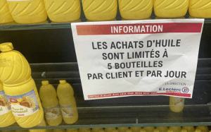 Une affiche indiquant aux clients d'un supermarché qu'ils ne peuvent pas achetées plus de 5 bouteilles d'huile par client et par jour.