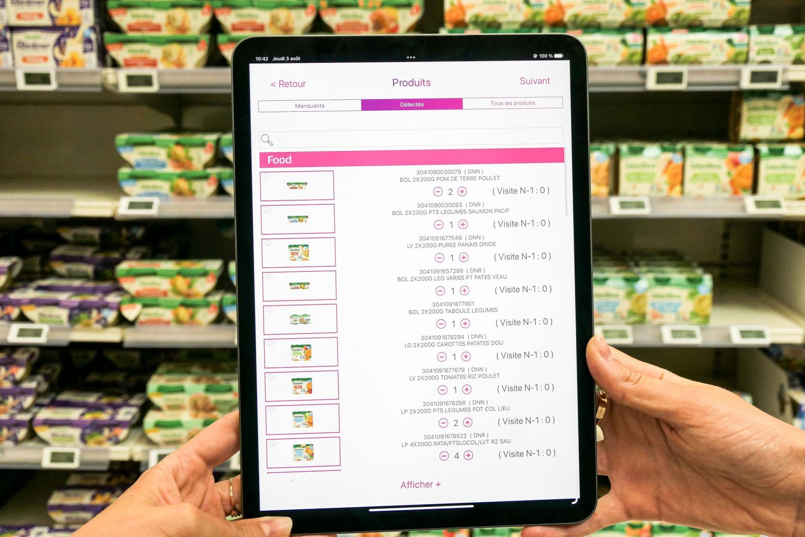 Une tablette affiche les produits qu'easypicky a scanné devant un rayon de nourriture pour enfant