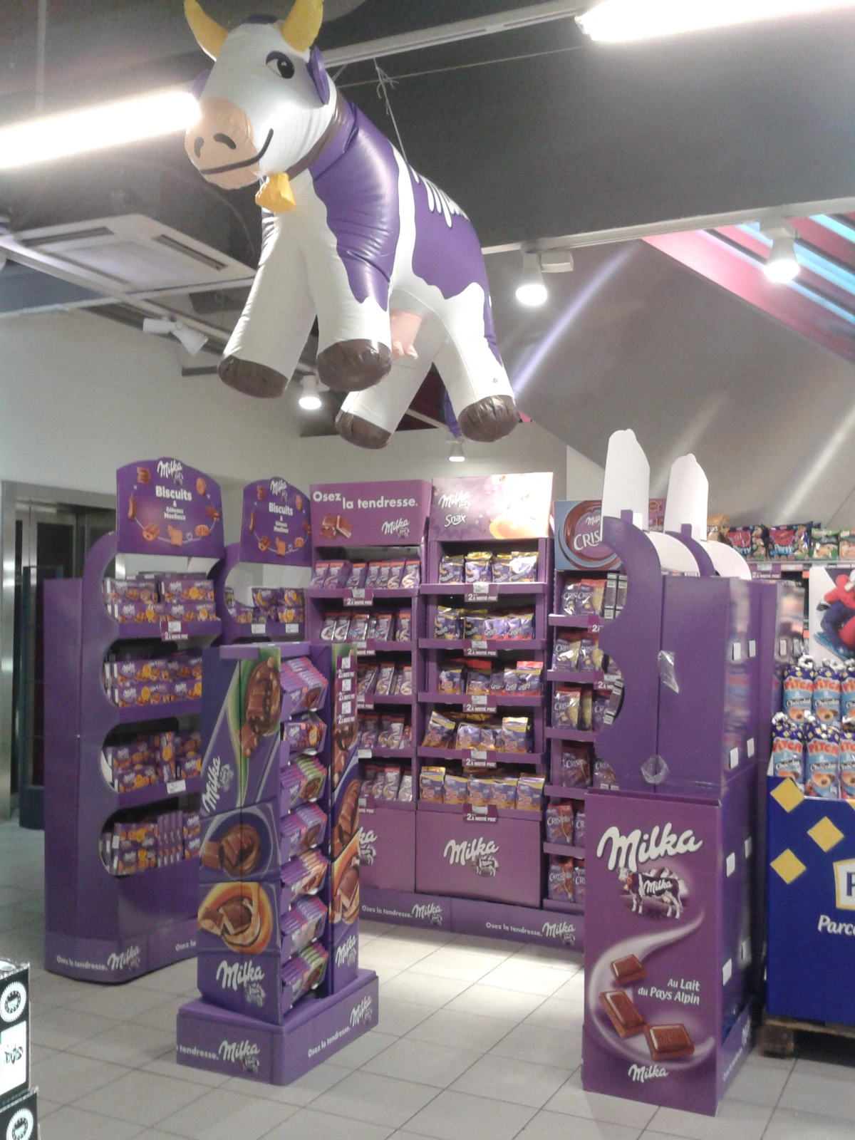 Un rayon de chocolat Milka avec une vache en ballon gonflable au dessus