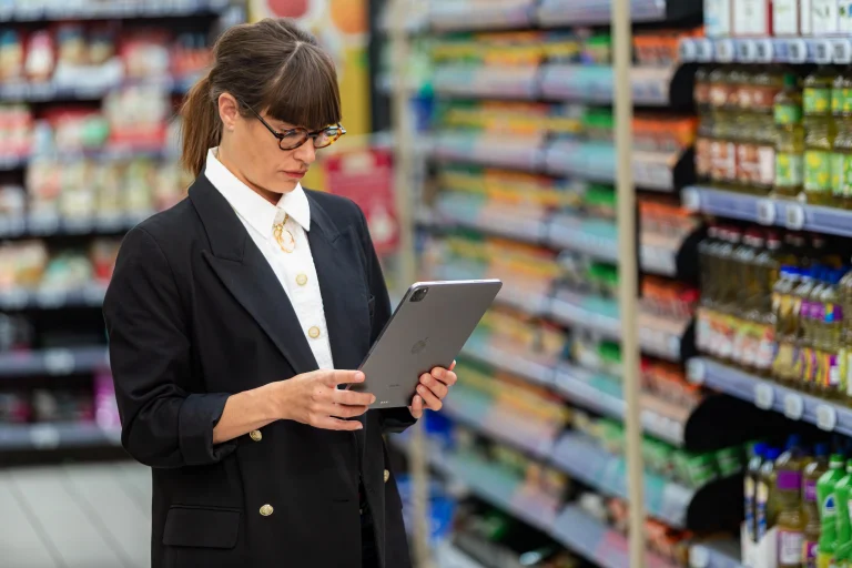 Field sales representative capturing shelf data automatically with the EasyPicky app in a supermarket aisle
